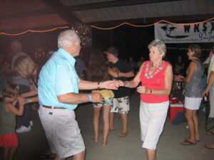 Families enjoying at a South Carolina marina with boats docked and kids playing nearby